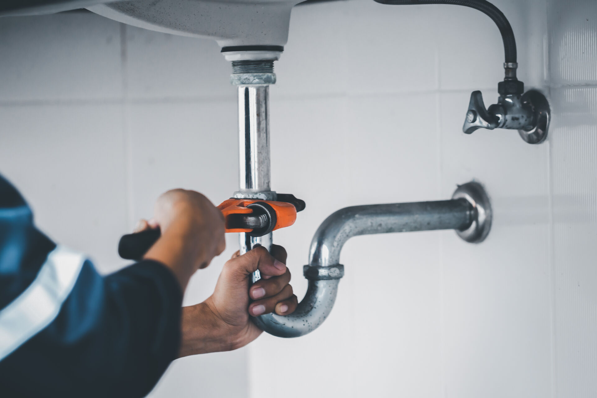Plumber working under a sink